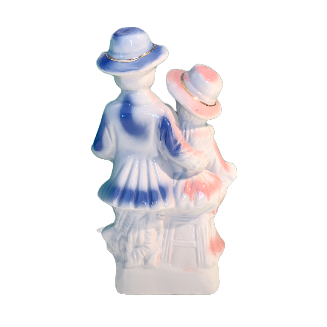 Porselensfigur av mann og dame i blå,rosa og gulldetaljer.